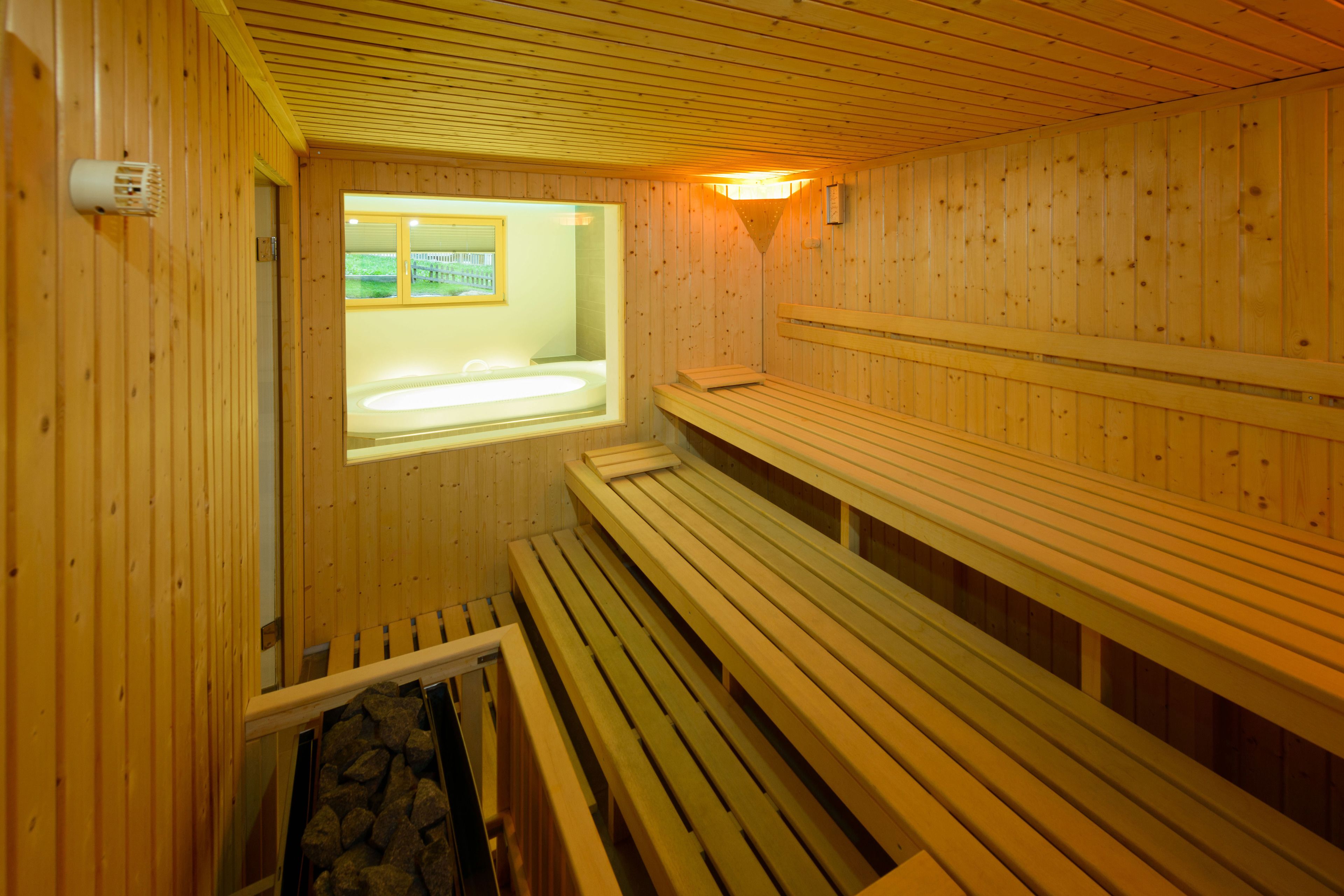 Un sauna avec des bancs en bois et une fenêtre.