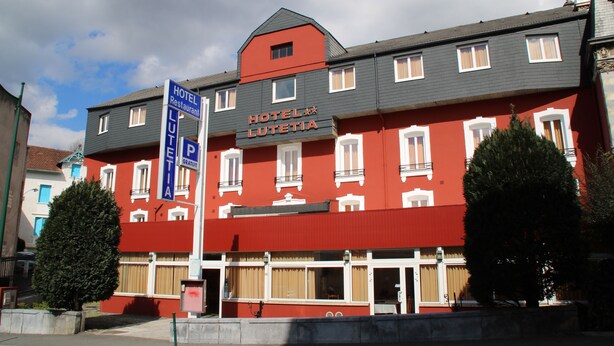 Een rood-wit hotel met een bord waarop staat dat er een restaurant is.