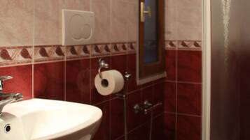 Un bagno completo di lavandino, specchio, wc e doccia.