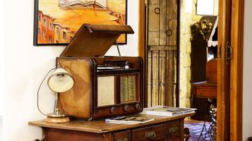 Een oude radio op een houten bureau met lades, een lamp en een schilderij op de achtergrond.