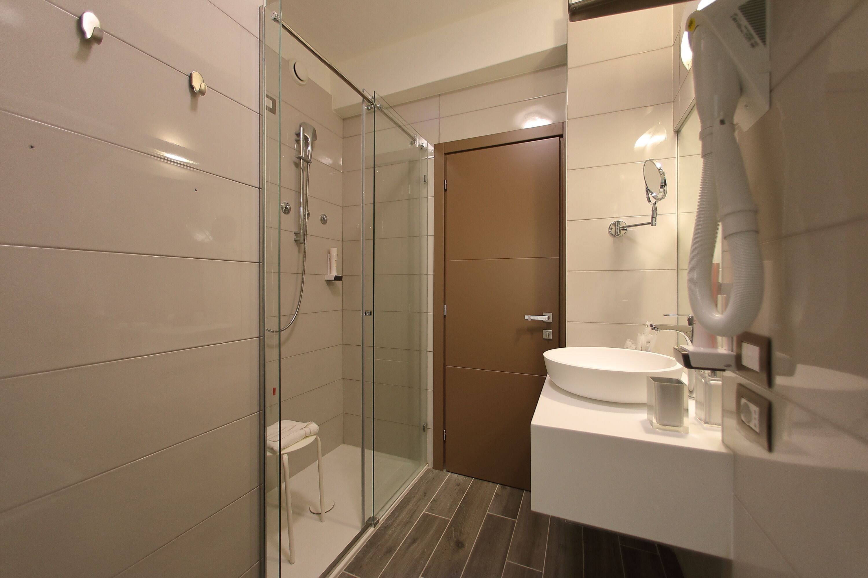 Une salle de bain moderne avec une douche à parois de verre, un lavabo blanc et des toilettes.
