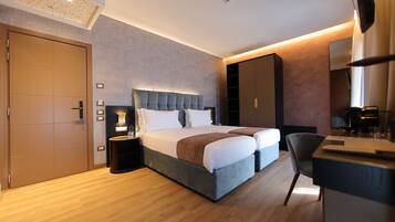 Ein modernes Hotelzimmer mit einem großen Bett, einem Schreibtisch und einem Sessel.