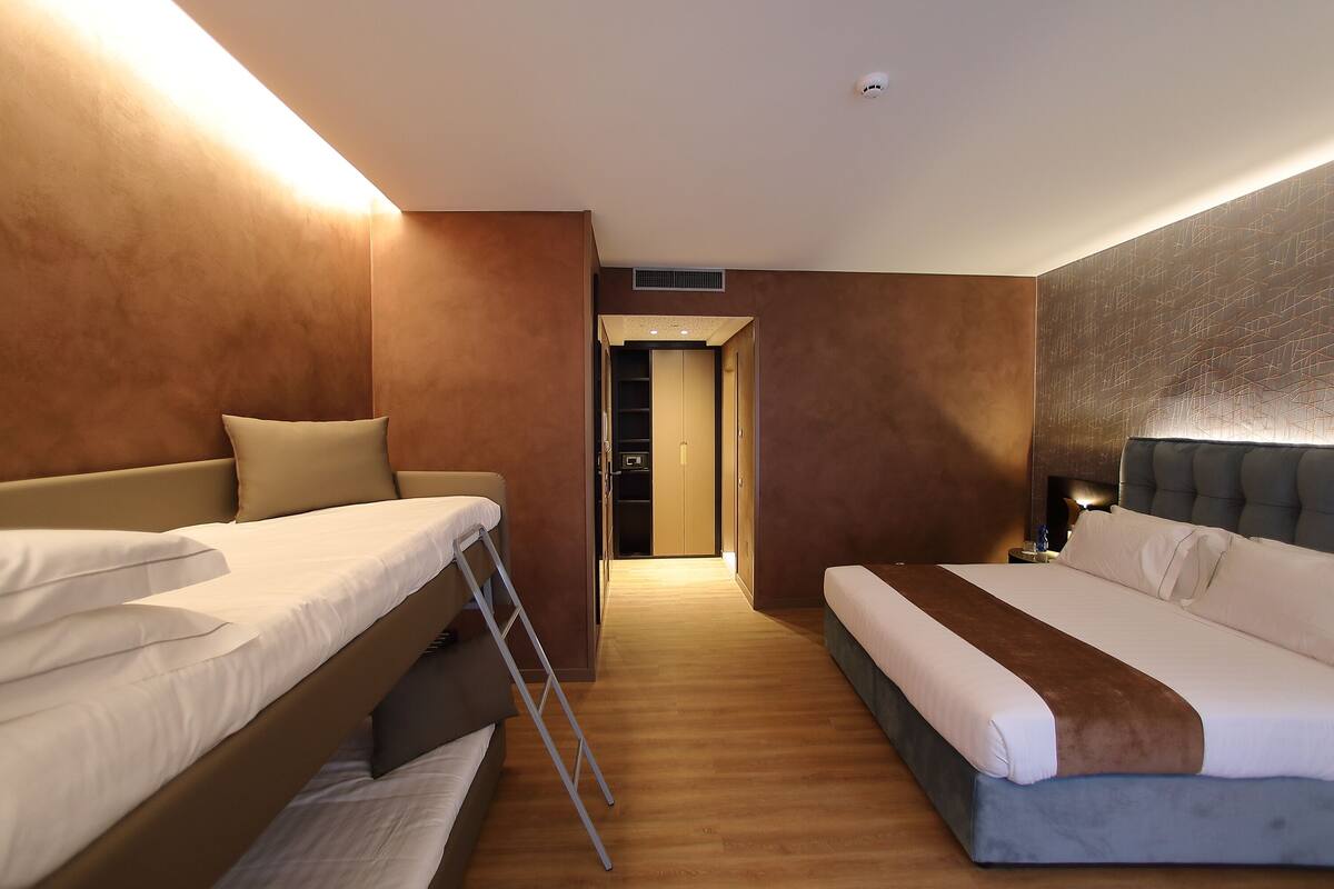 Een hotelkamer met twee bedden, een kledingkast en een badkamer.