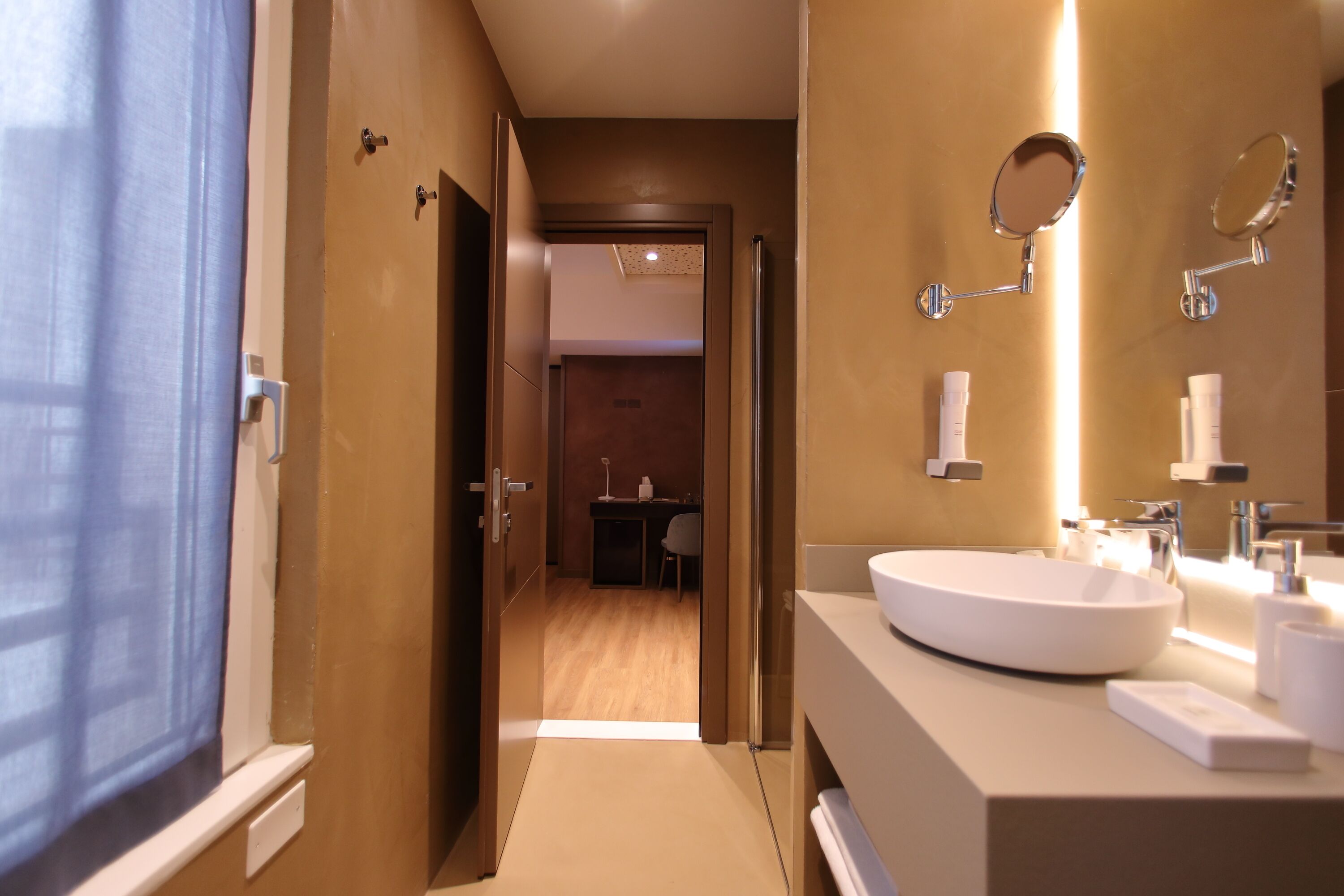 A modern bathroom with a large sink, mirrors, and a shower area.