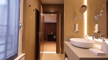 Un baño moderno con un lavamanos grande, espejos y zona de ducha.