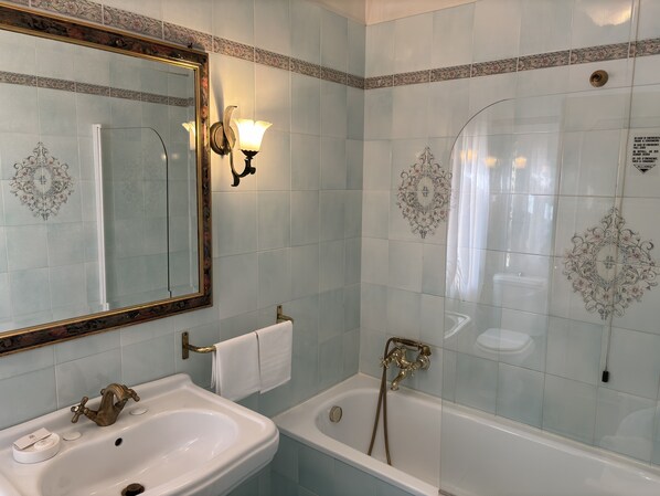 Une salle de bain avec un lavabo, un miroir et une baignoire.