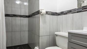 A bathroom with a shower, toilet, and a towel rack.