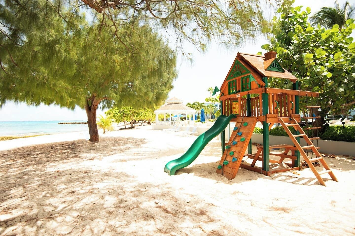 A beach playground with a slide and climbing structure.
