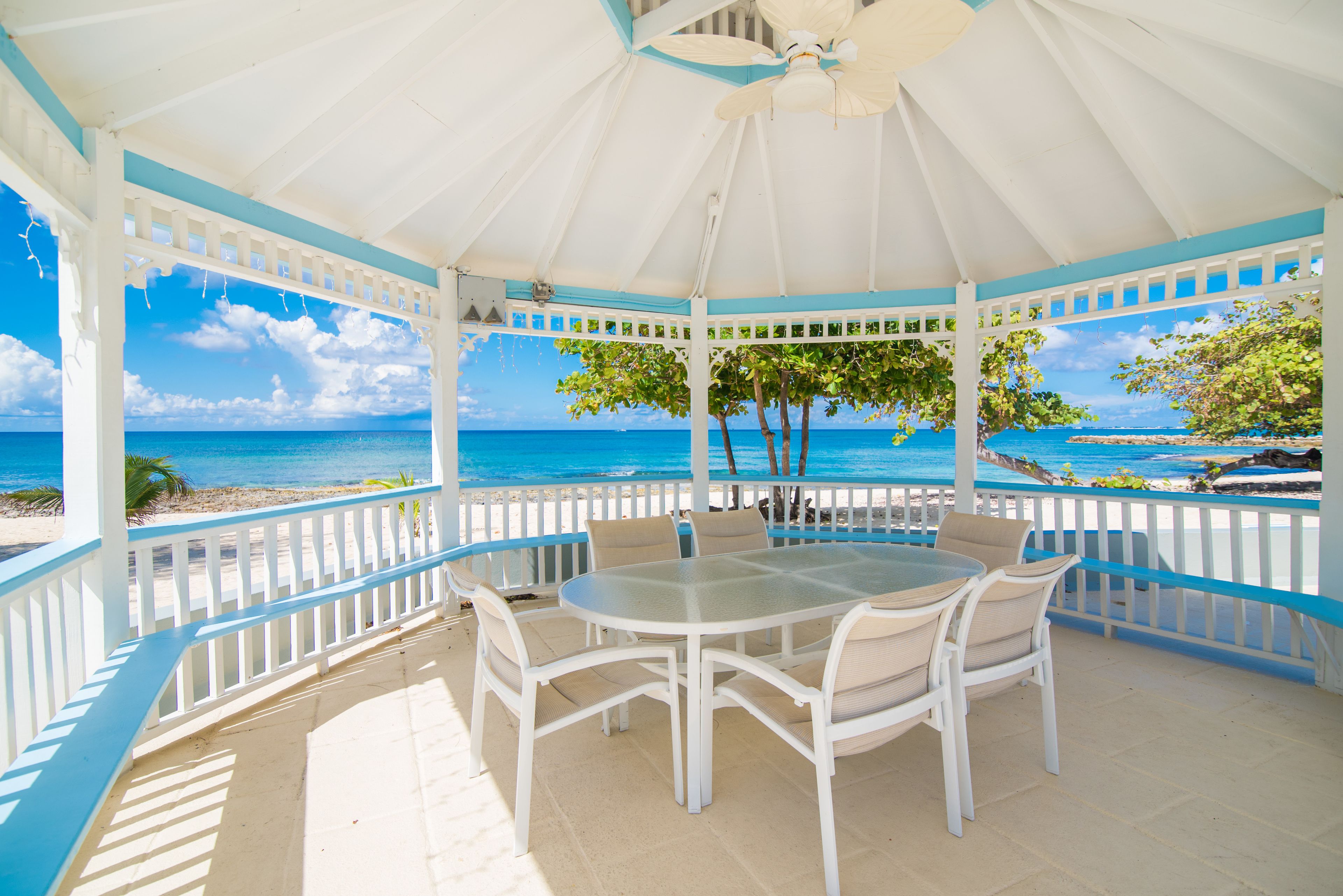 A covered outdoor seating area with a view of the ocean.
