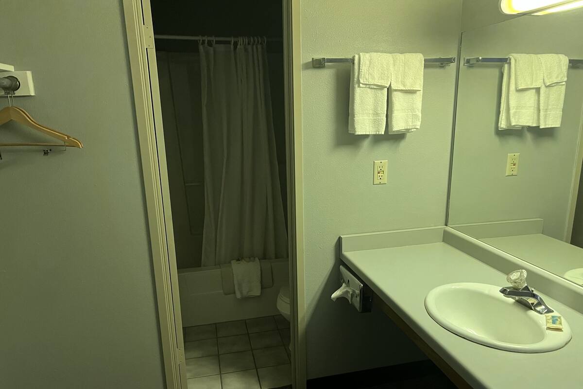 A bathroom with a white sink, a mirror, and a shower curtain.