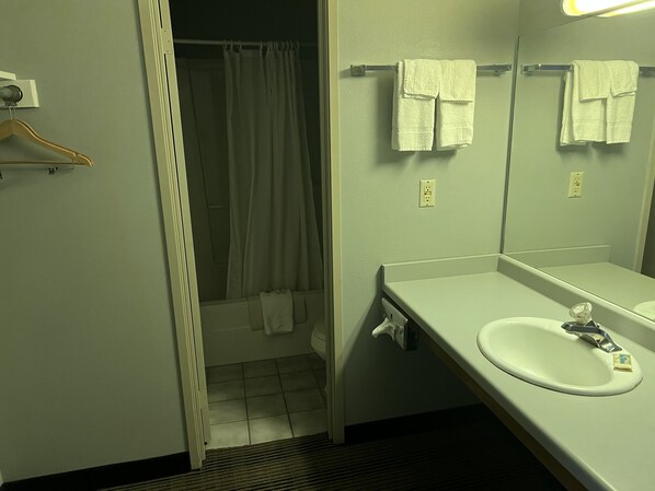 A bathroom with a white sink, a mirror, and a shower curtain.