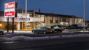 A Dino's restaurant and lounge with a brick exterior and multiple parked cars in front. - The Ridge Hotel Portage (Portage)