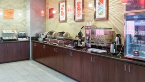 A breakfast bar with a coffee machine, tea station, and a refrigerated display.