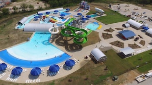 An aerial view of a water park with multiple slides, pools, and lounge areas.