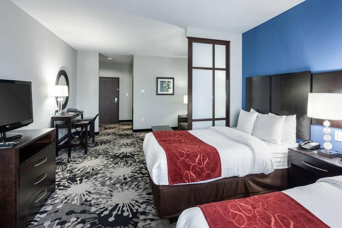 Une chambre d’hôtel avec un lit, un bureau, une télévision et une table de chevet.