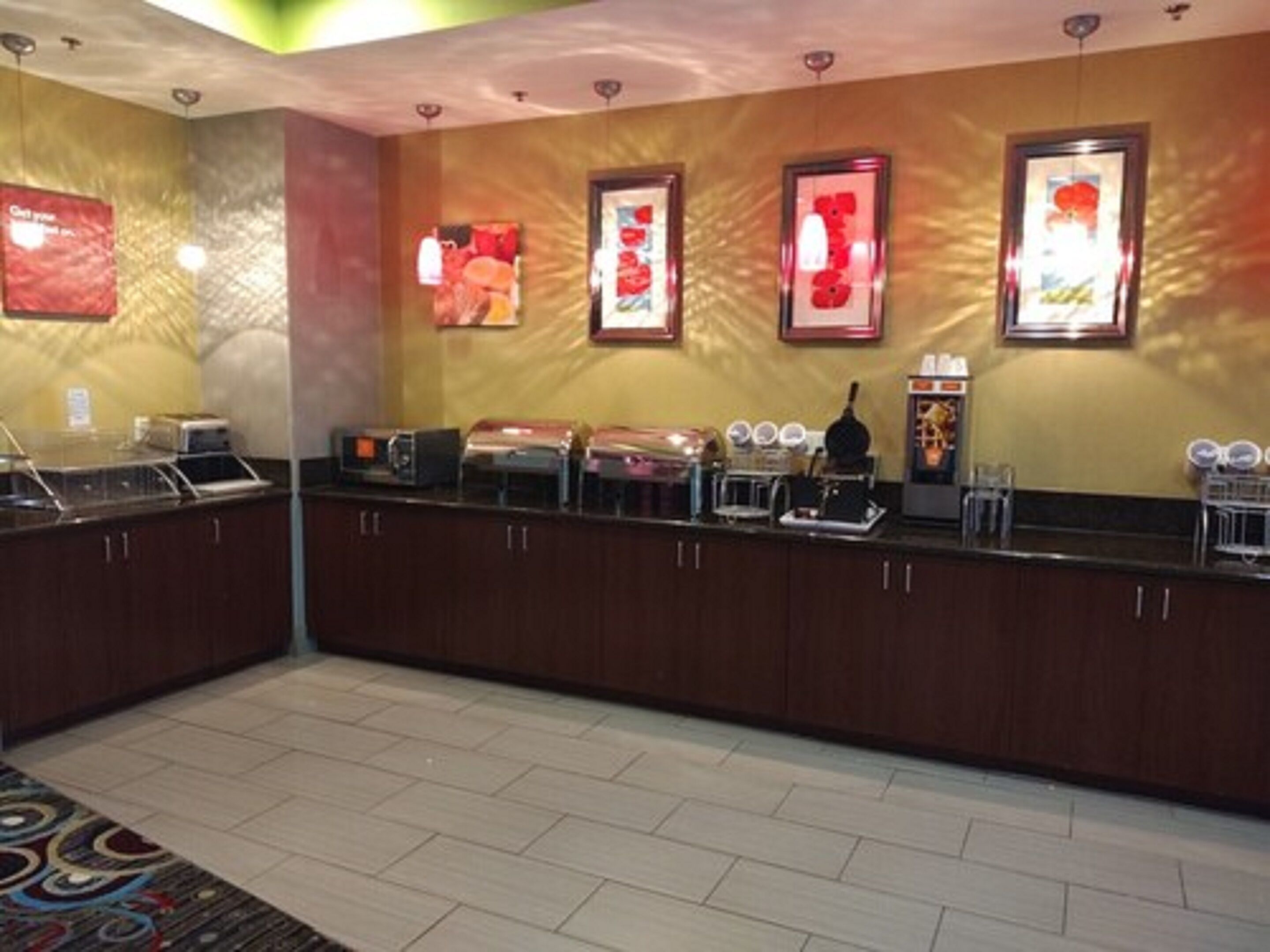 A buffet area with a counter, microwave, and various food items.