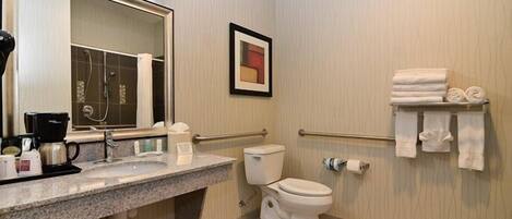A bathroom with a sink, mirror, toilet, and towel rack.