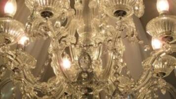 A chandelier with multiple arms and candle-like lights.