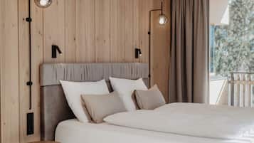 Un dormitorio moderno con una cama grande, paneles de madera en las paredes y dos luces fijadas a la pared.