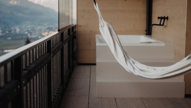 A hammock in a modern bathroom with a view of mountains. -  Hotel Berghof | St. Johann in Salzburg (Sankt Johann im Pongau)