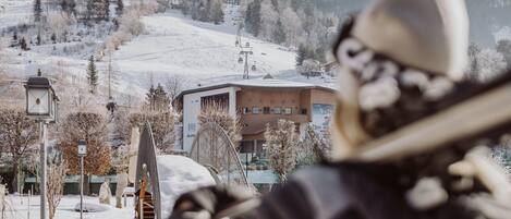 A ski resort with a chairlift, buildings, and snow-covered trees.