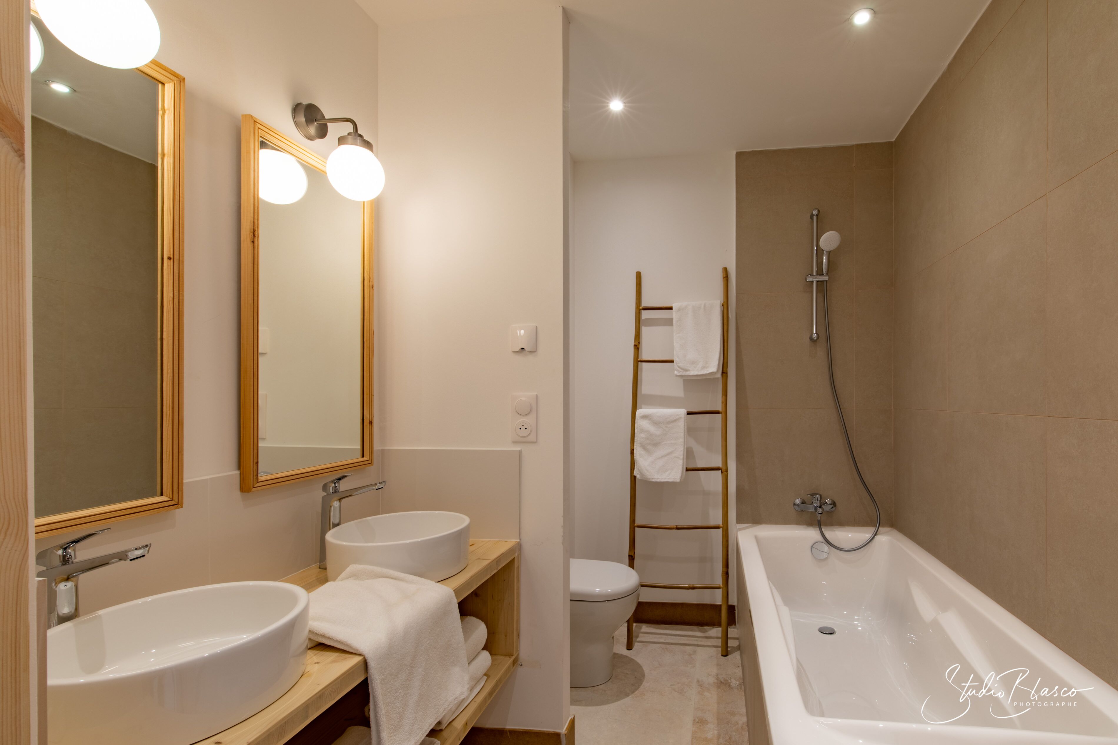 Ein modernes Badezimmer mit zwei Waschbecken, einer Badewanne und einer Toilette.