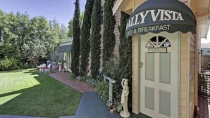 Un bâtiment sur lequel est apposée une enseigne indiquant « Ballivista Bed & Breakfast », et une pelouse bien entretenue agrémentée de mobilier d’extérieur.