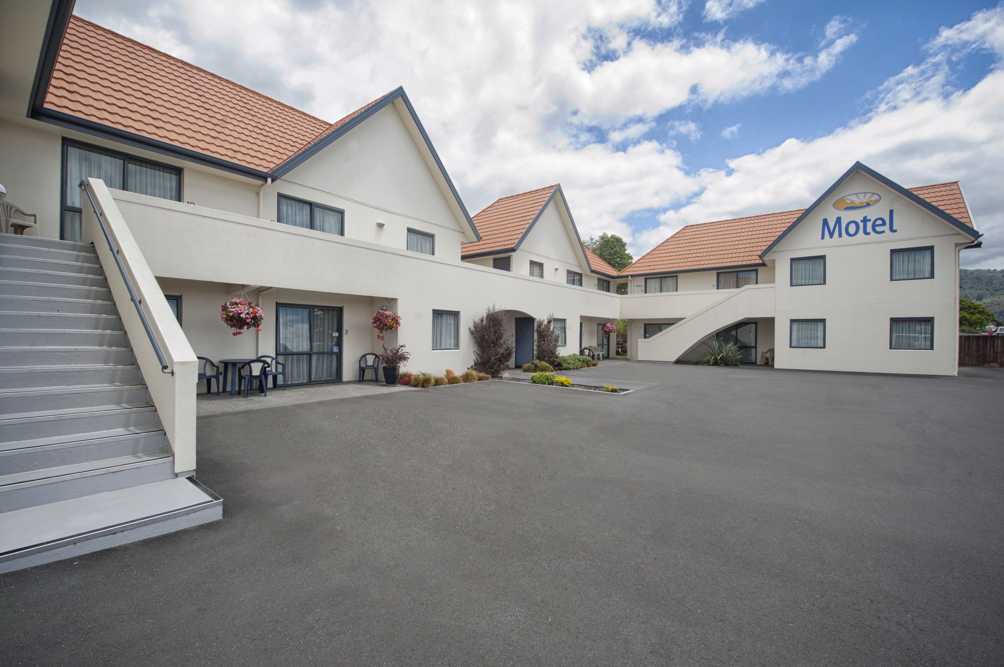 Ein Motel mit Innenhof, mehreren Gebäuden und einer Treppe, die zum Eingang führt.