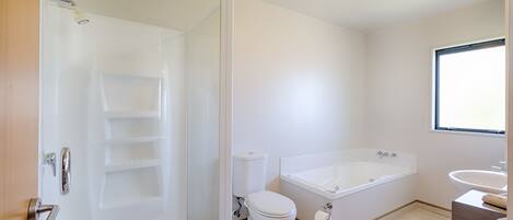 A bathroom with a toilet, bathtub, and sink.