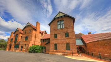 A large brick building with multiple towers and arched windows, likely a historic or institutional building.