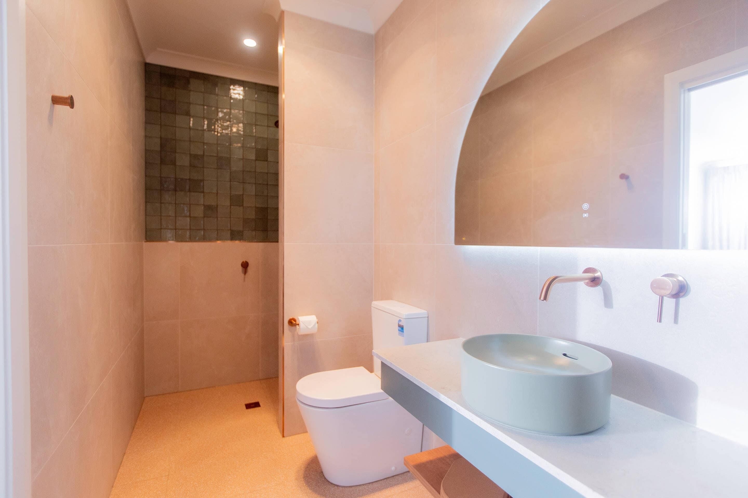 Ein modernes Badezimmer mit Toilette, Waschbecken und Dusche.