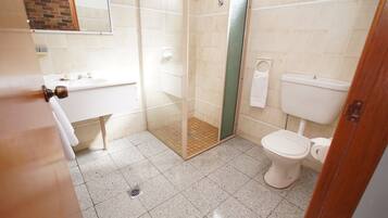 Un baño con ducha, inodoro y lavamanos.