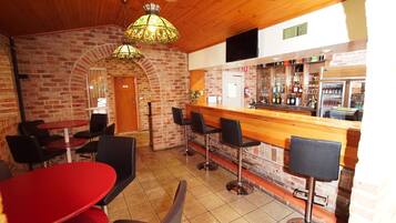 A restaurant with brick walls, wooden ceiling, and a bar area with stools.