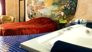 Habitación de hotel con una cama grande, una bañera, una silla y un mural de un jardín.