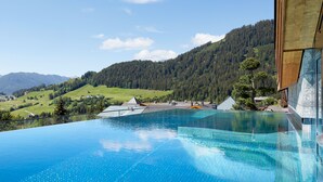 A swimming pool with a view of a mountainous landscape. - Hotel Tirol (Fiss)