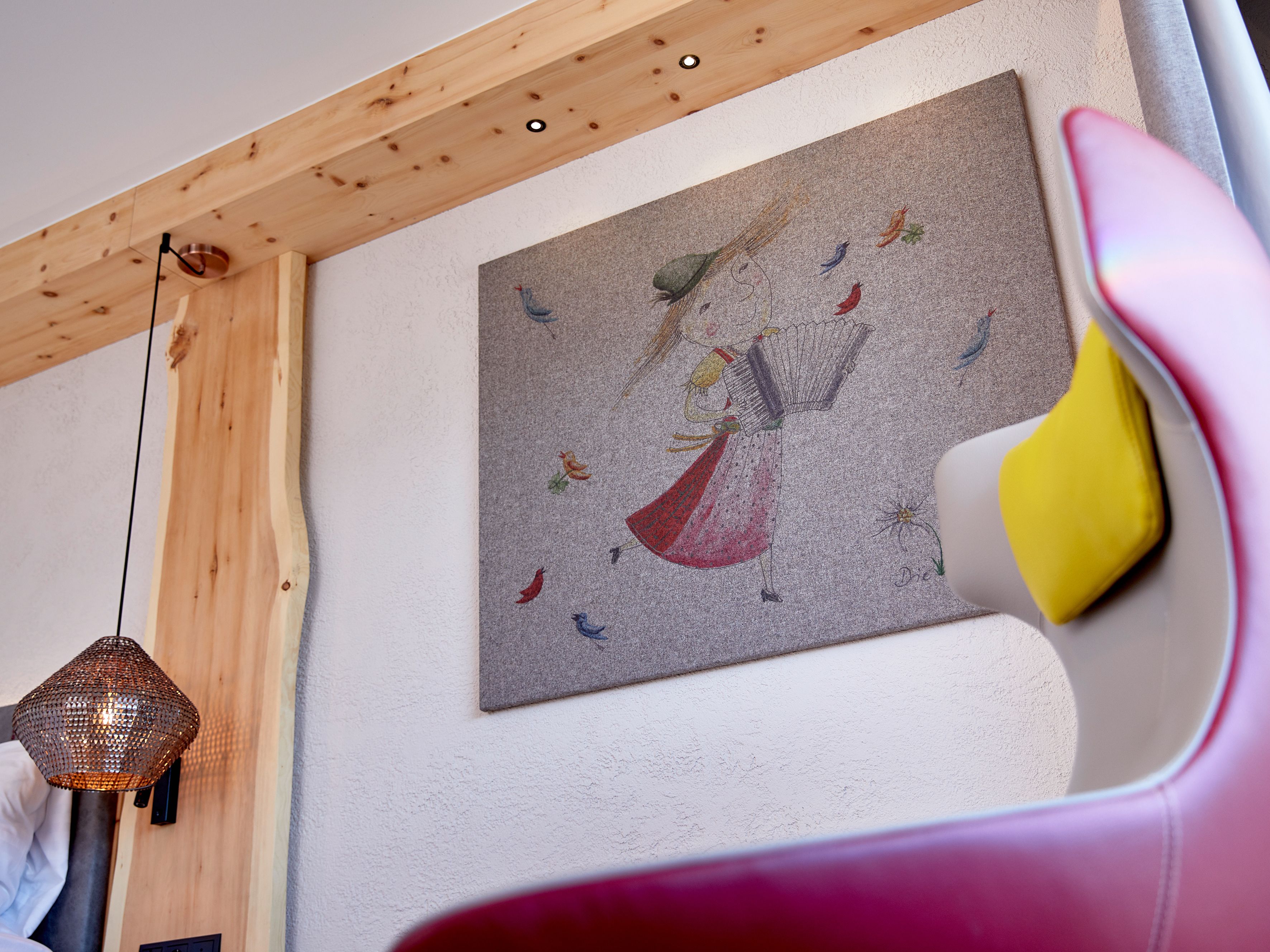 Una habitación con techo de madera, una obra de arte en la pared que representa un pavo real y pájaros, y una lámpara colgante.