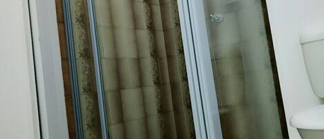 A shower area with a glass door and a tiled floor.