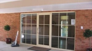 A building entrance with a glass door and brick walls. - Gabriel Motor Inn (Gundagai)