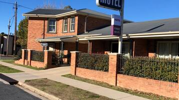 A motel named Gabriel with a signboard, a brick building, and a fenced parking area.