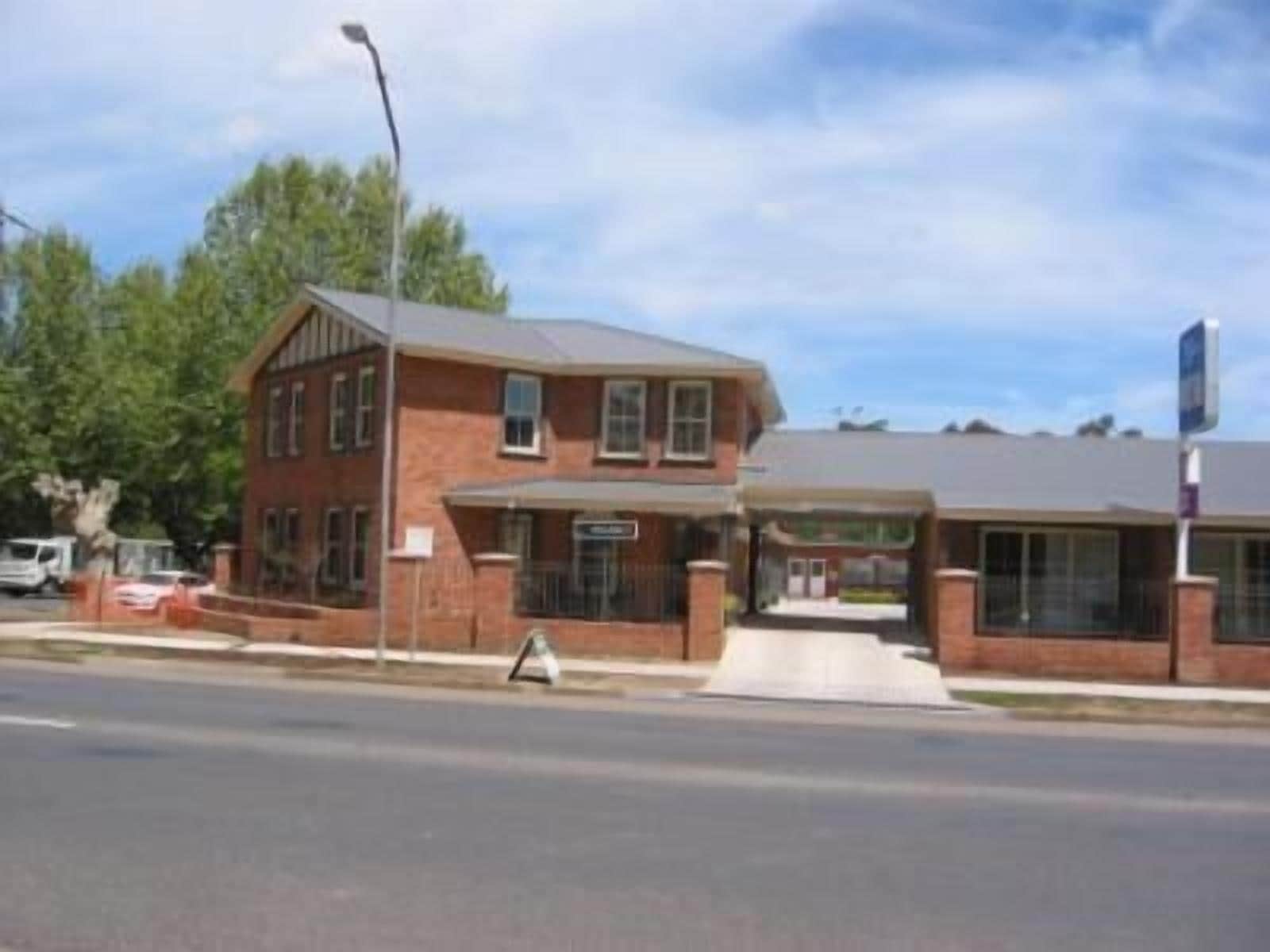 A two-story brick building with a covered entrance and a small ramp leading to the door.