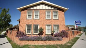A two-story brick building with a flat roof and a sign indicating it is a motel. - Gabriel Motor Inn (Gundagai)