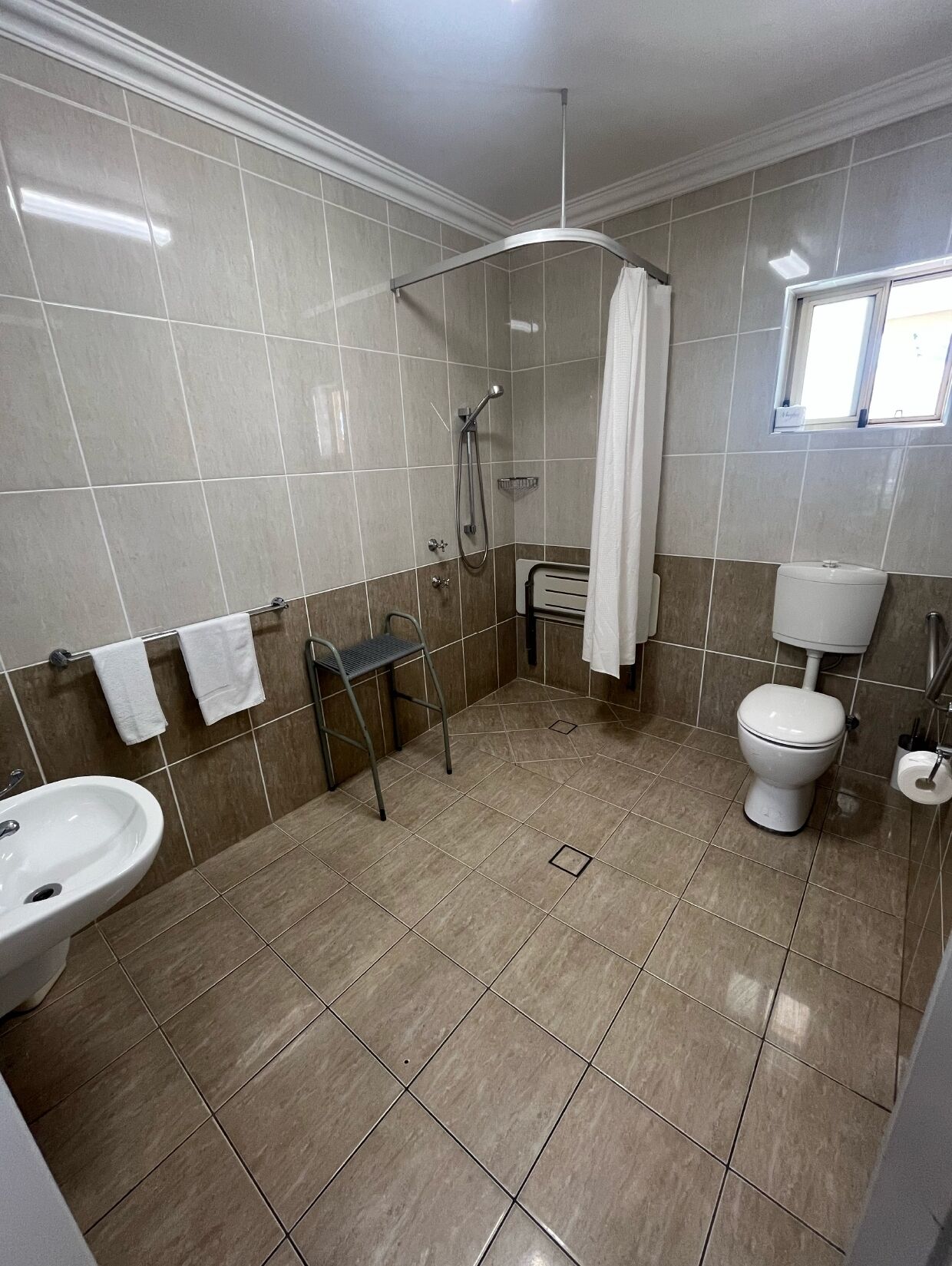 Kylpyhuone, jossa on suihku, wc, pesuallas ja pyyheteline.