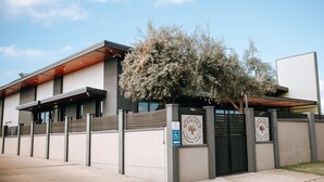 Un edificio moderno con un cartel que dice 'MISLINA BAR & GRILL' y una entrada accesible para sillas de ruedas.