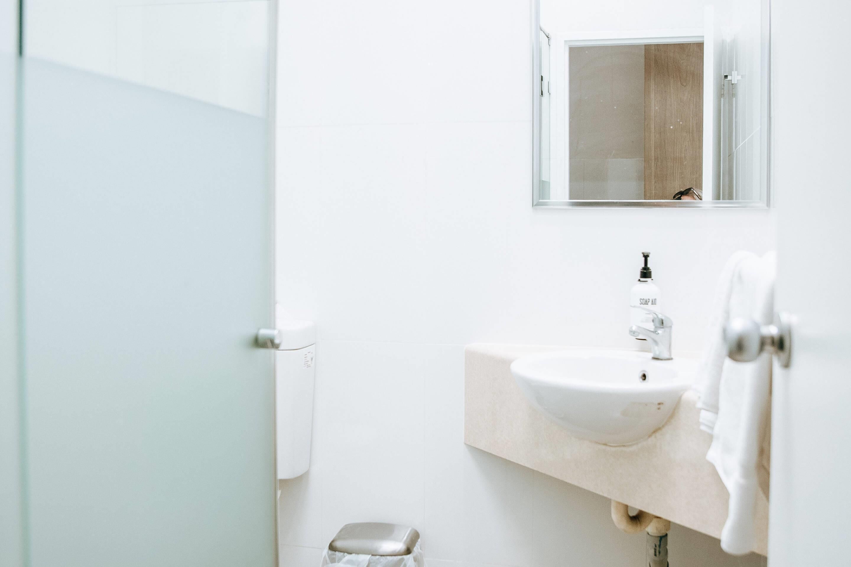 Un baño moderno con un lavabo blanco, un espejo y un inodoro.