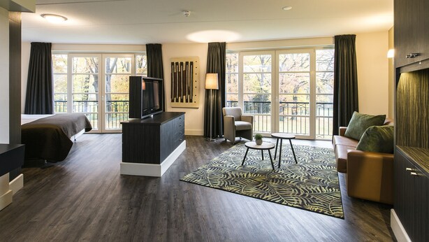 A modern living room with a sofa, armchair, and TV stand.