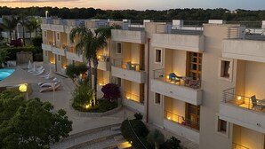 Un hotel de varios pisos con zonas de estar al aire libre y una piscina.