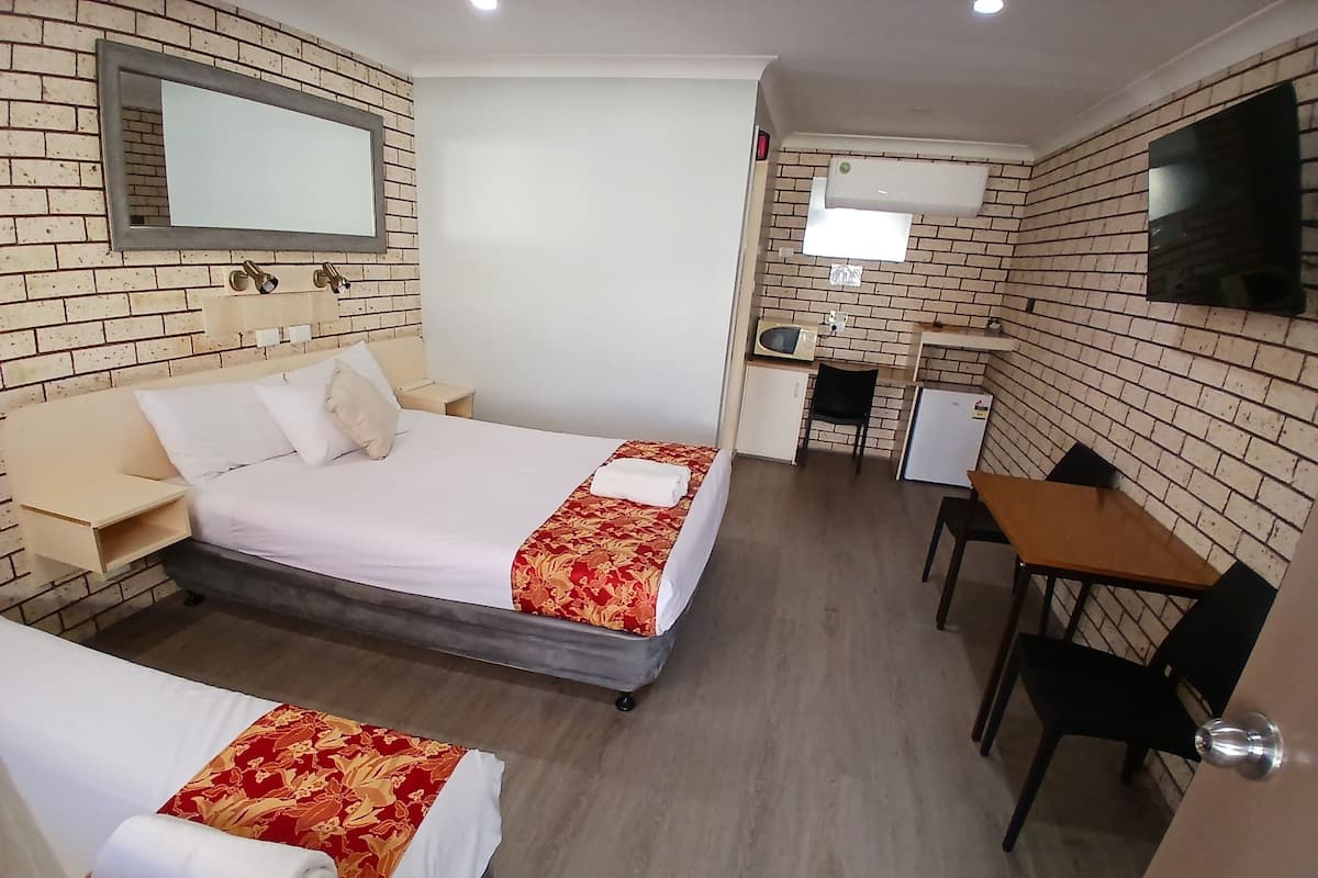 Una habitación de hotel con una cama, un escritorio y una silla.