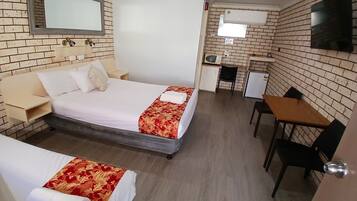 A hotel room with a bed, a desk, and a chair.