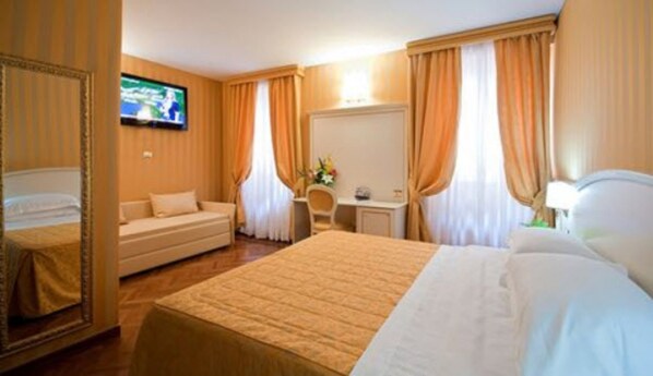 A hotel room with a large bed, a sofa, a desk, and a television. - Trevi 41 Hotel (Rome)