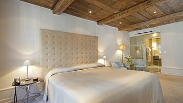 Une chambre avec un grand lit, une table de chevet avec une lampe et un plafond en bois.